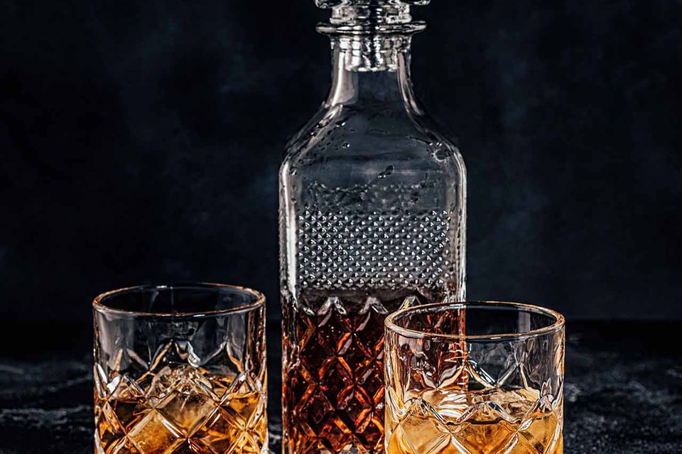 Whisky in alten Gläsern und Whiskyflasche