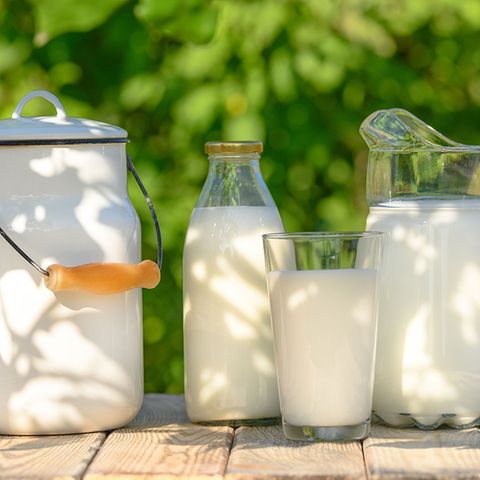 Milch in Krug, Glas und Flasche auf Holztische