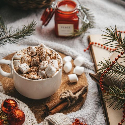 Tasse mit Marshmallows mit Weihnachtsdeko auf Tisch