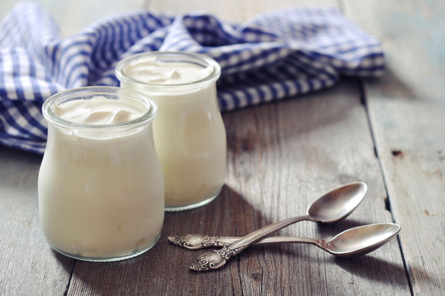 cremiger Joghurt in kleinen Gläsern auf Holztisch