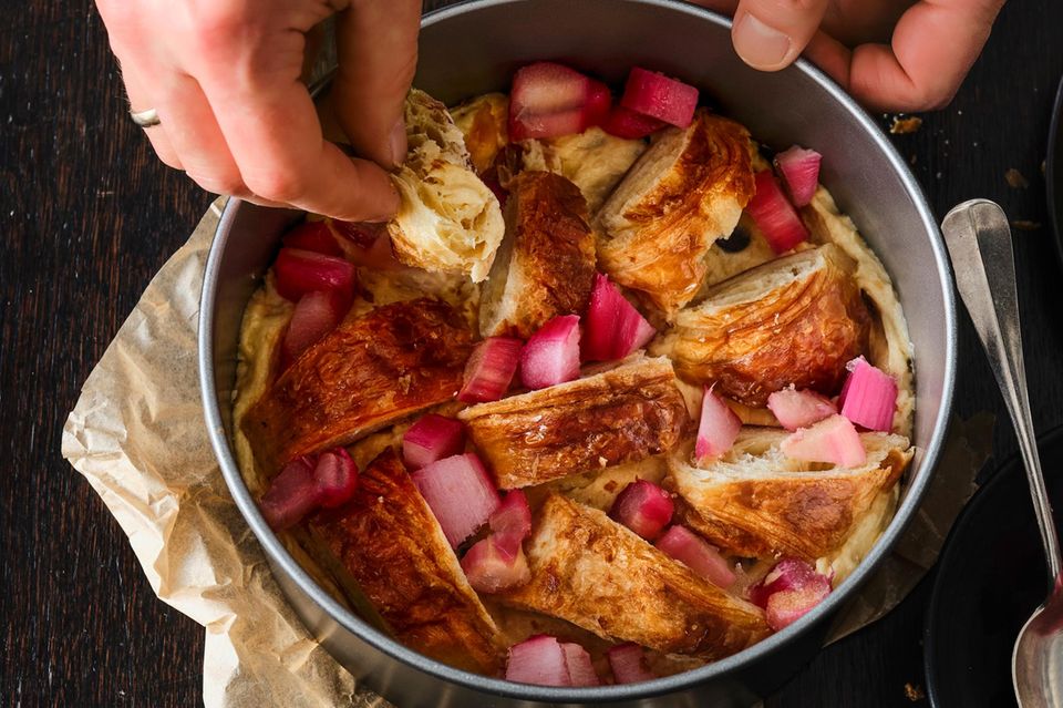Croissants und Rharaberstücke auf den Teig geben