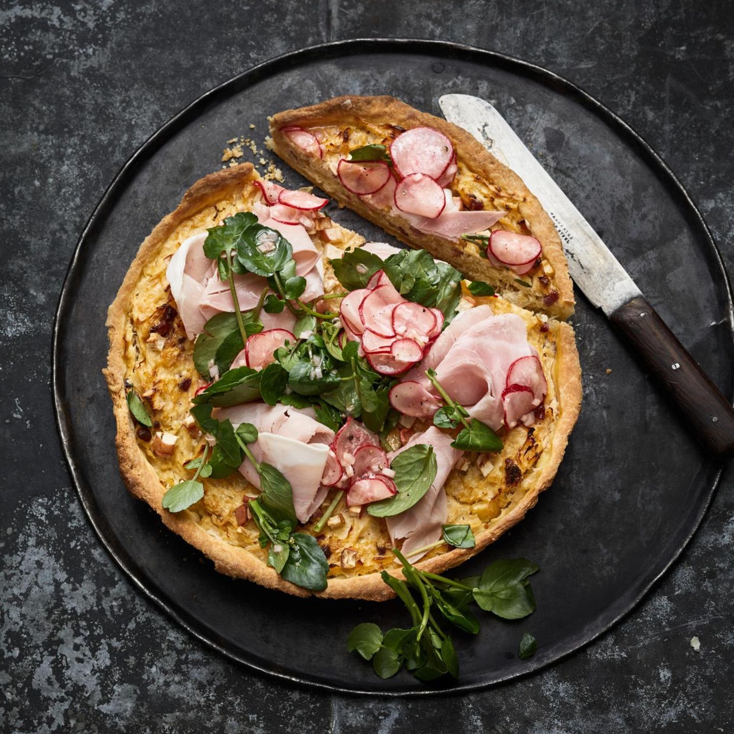 Rahmsauerkraut-Quiche mit Äpfeln, Speck, belegt mit gekochtem Schinken, Brunnenkresse und Radieschen-Vinaigrette