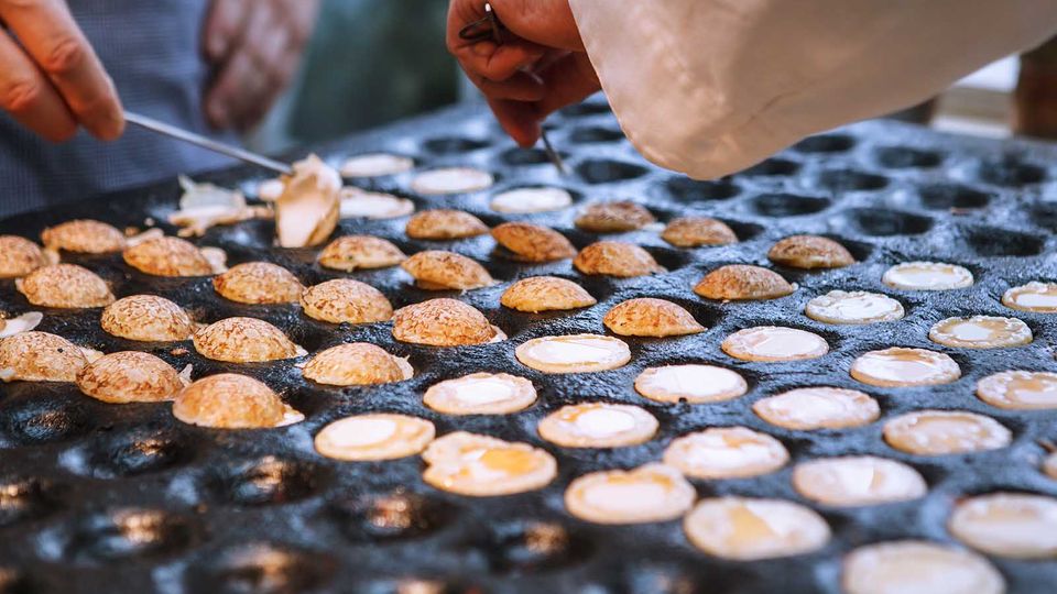 Auf Jahrmärkten werden Poffertjes in Profi-Eisen zubereitet, damit eine große Menge Poffertjes gleichzeitig gebacken werden kann.