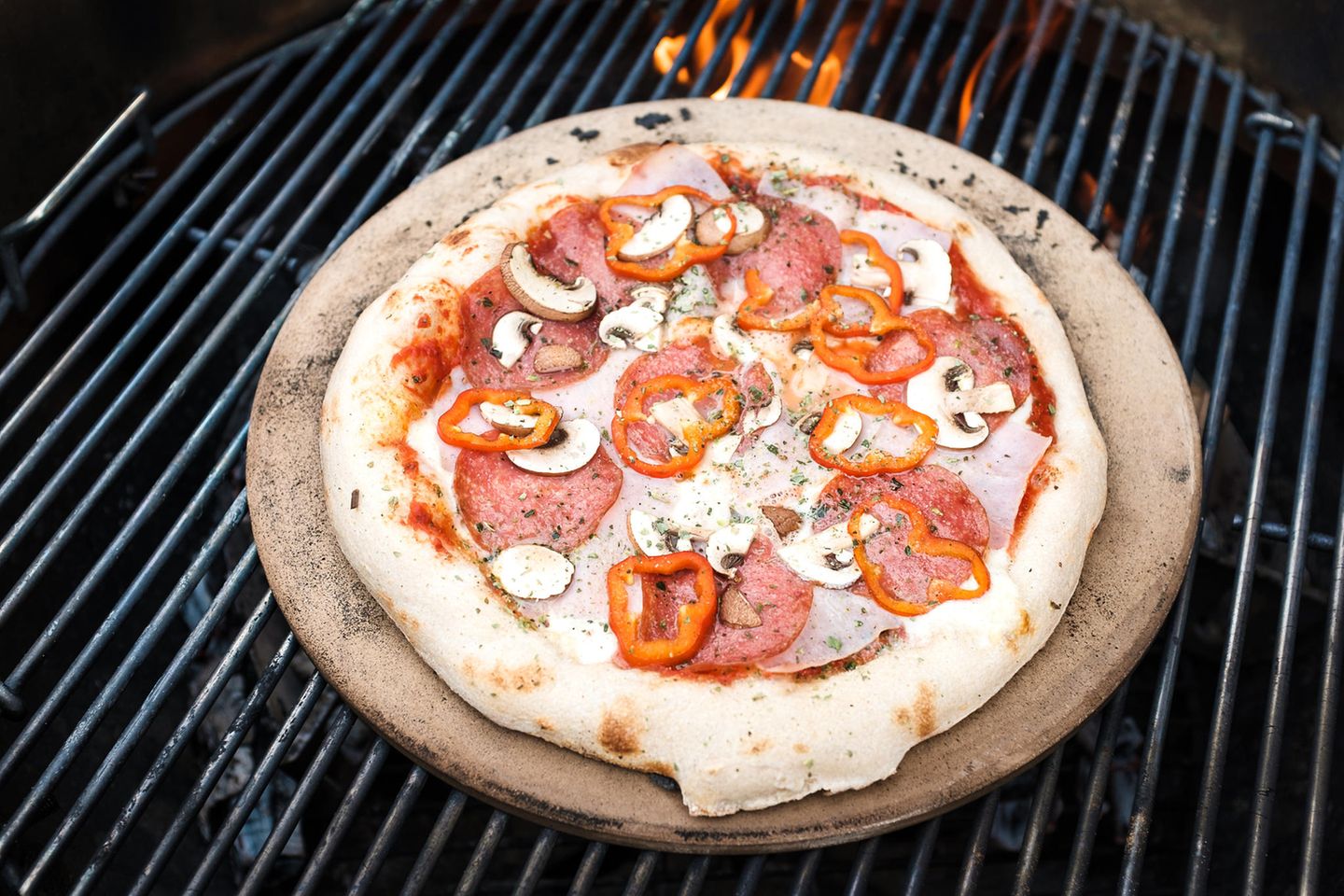 Pizza and pizza stone on the grill
