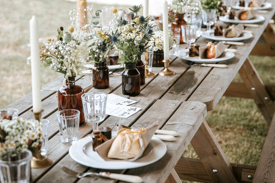 Schlicht und natürlich ist eine Hochzeitstafel im nachhaltigen Look. Die Blumen kommen teils frisch von Wiesen und Feldern – und als Vasen können recycelte Flaschen zum Einsatz kommen.