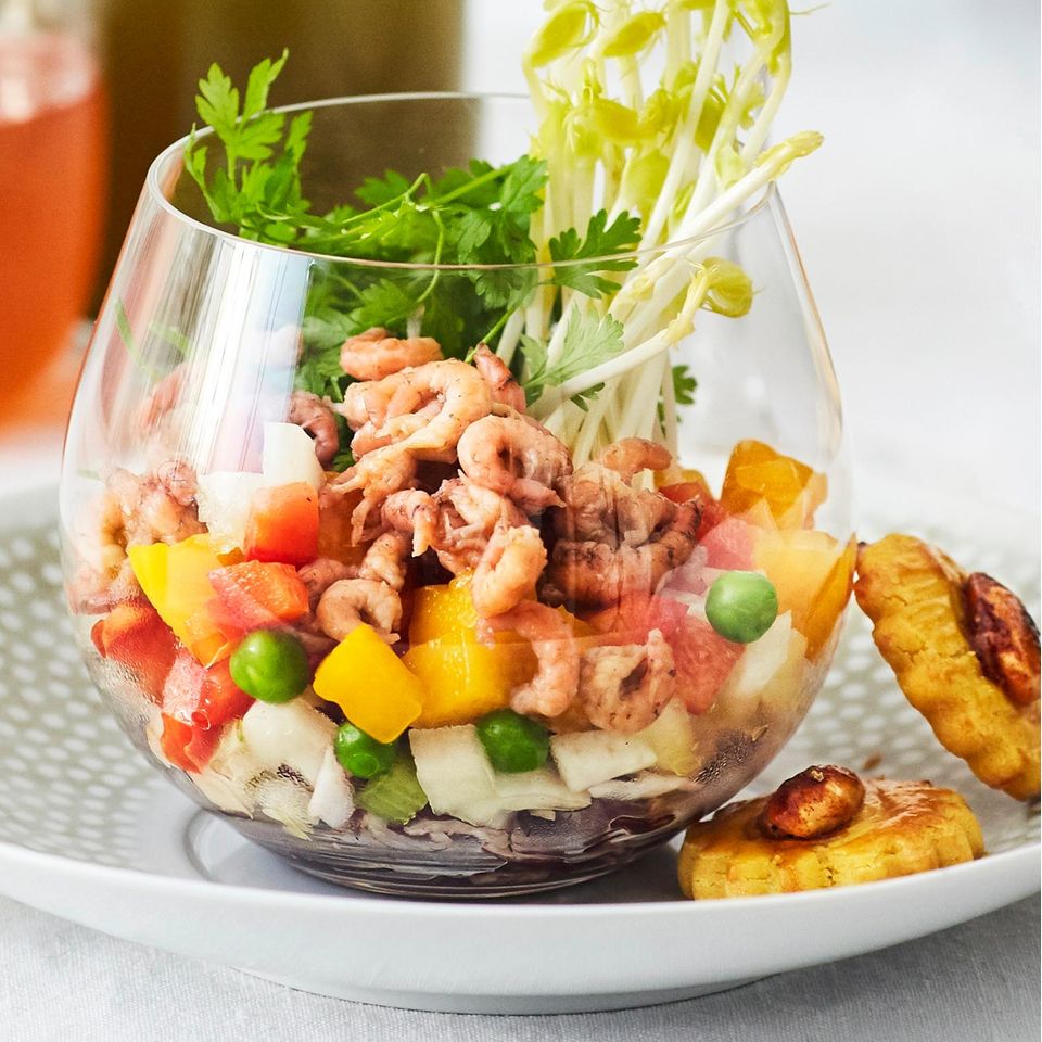 Gemüsecocktail mit Krabben. Serviert in einem Glas. Mit Kerbelblättern und Sprossen garniert.