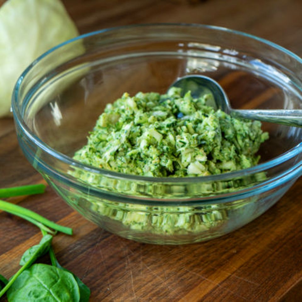 Green Goddess Salat aus Spitzkohl, Frühlingszwiebeln, Gurke und Schnittlauch mit leuchtend grünem Dressing in einer Schüssel.